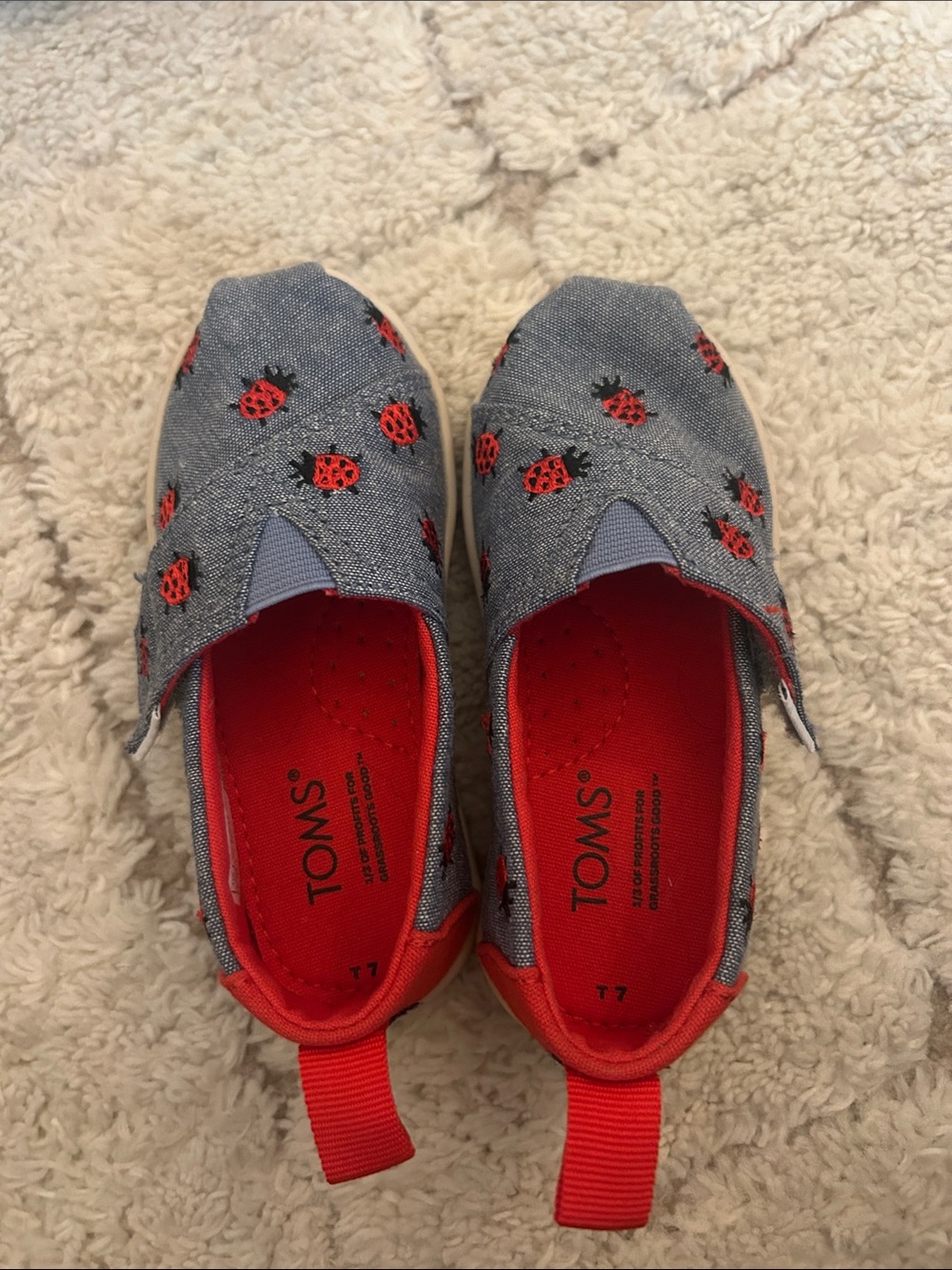 Toms size 7 (toddler) Denim Blue Slip-Ons with Red Ladybug Accents